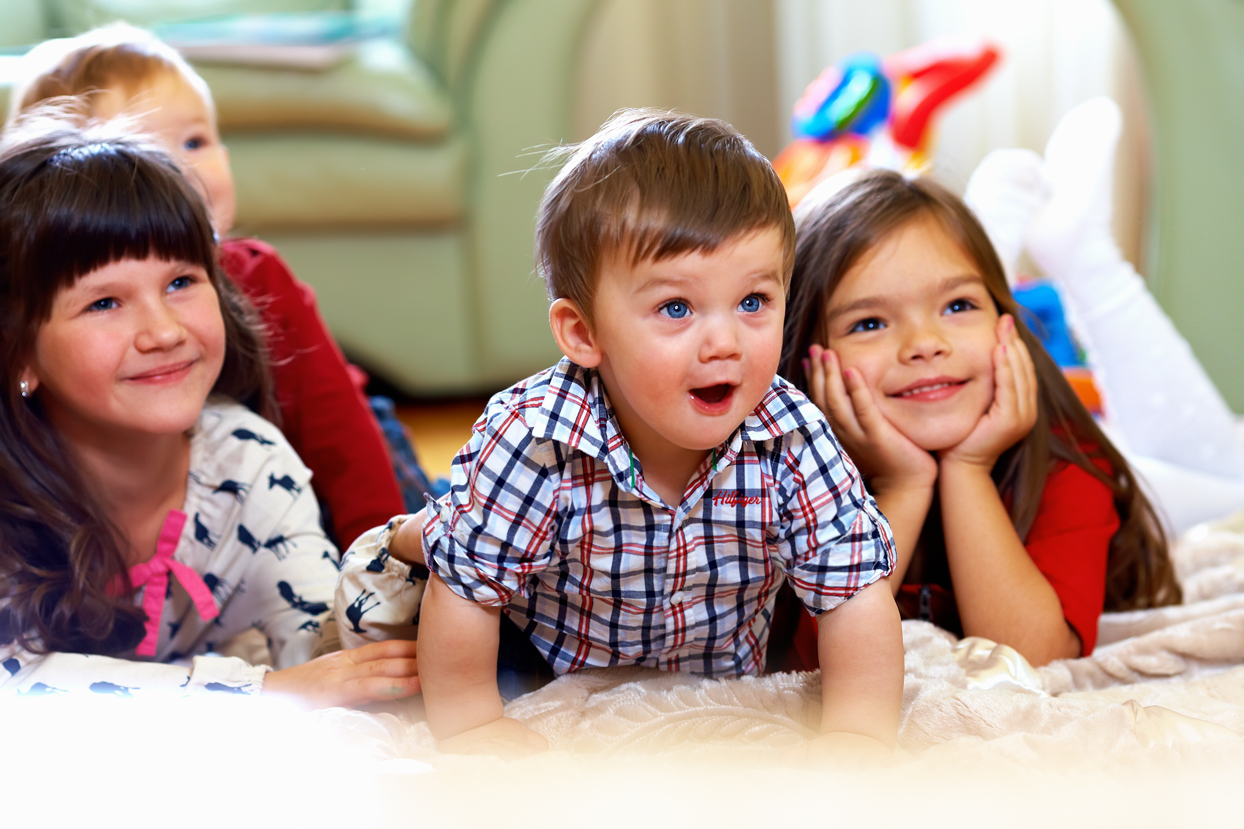 Kindergarten I Krippe Kinder liegen lachend auf Boden