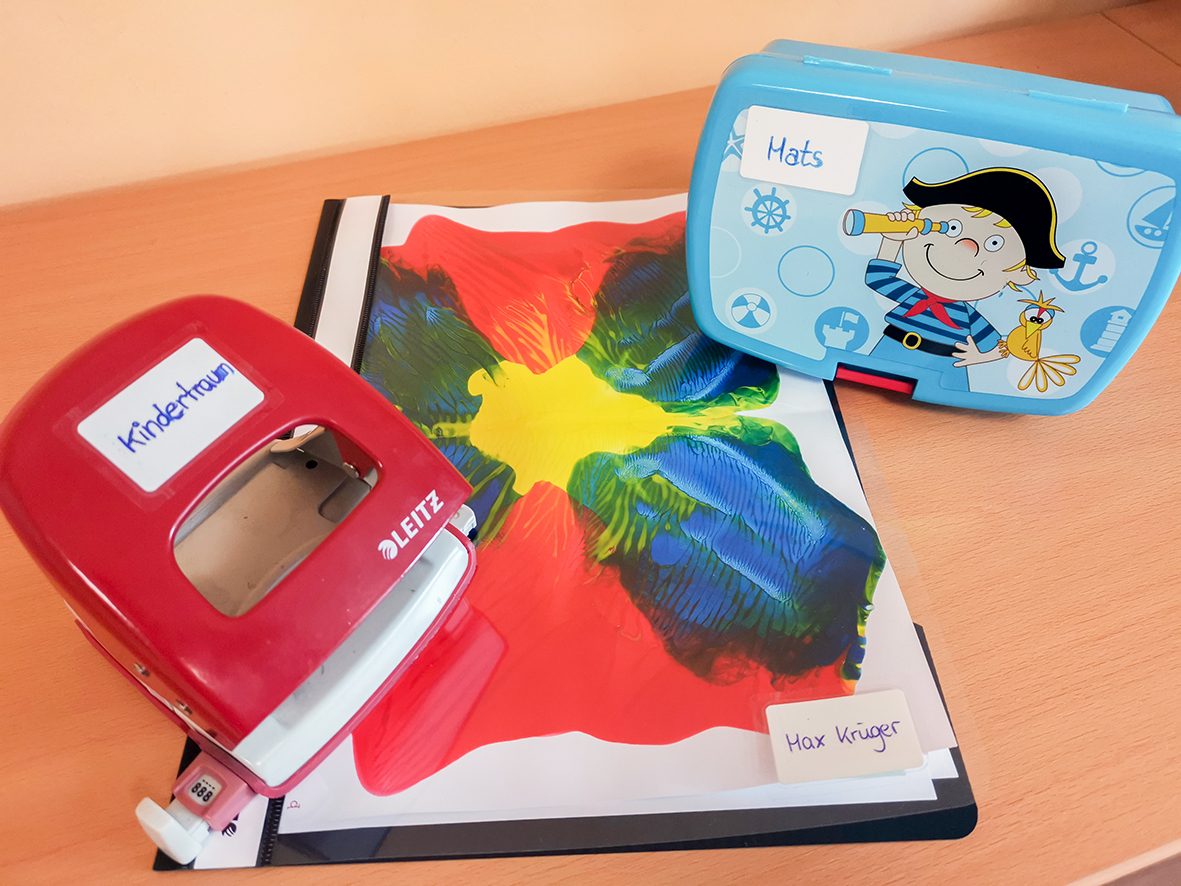 Selbstlaminierende Etiketten auf Locher, Brotdose und Mappe Selbstlaminierende Etiketten auf Locher, Brotdose und Mappe