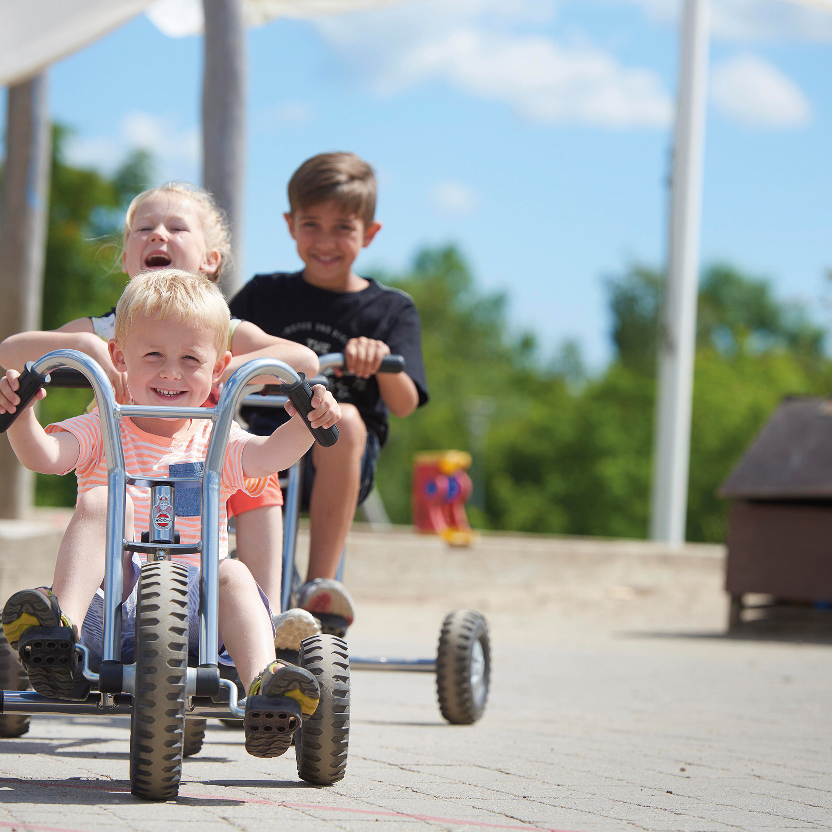 Winther Fahrzeuge Kinder fahren draussen mit Winther Fahrzeugen