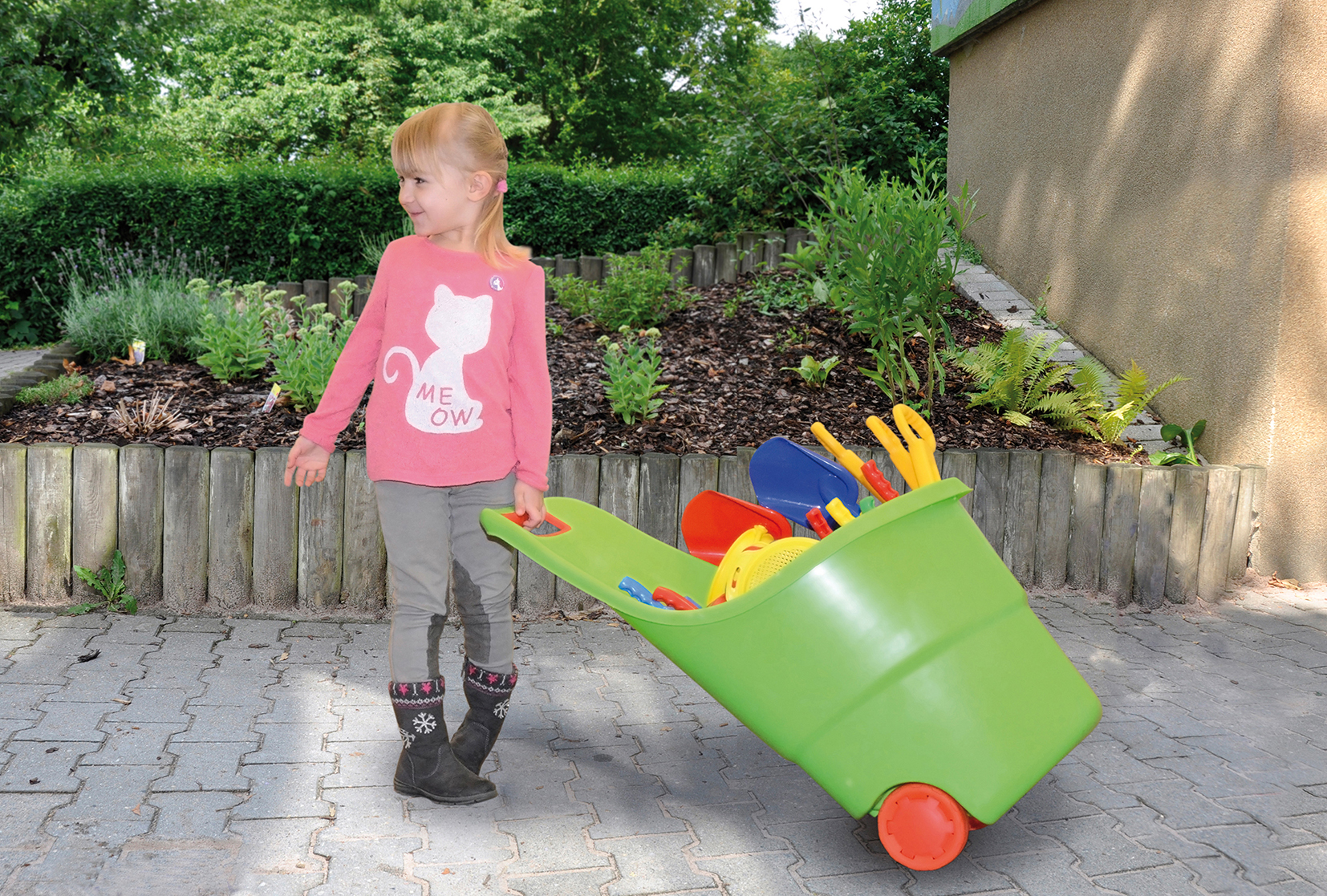 Mädchen zieht Transporteimer mit Sandspielzeug