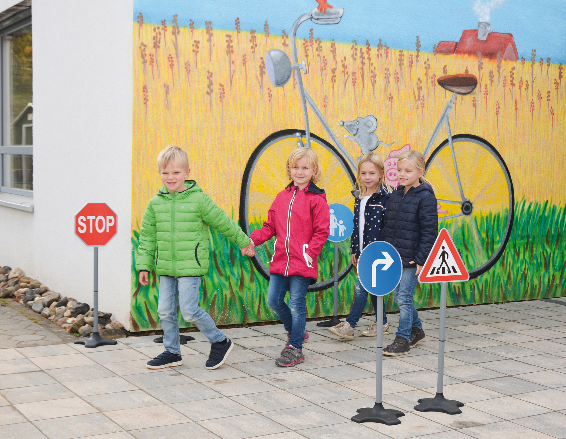 Kinder laufen durch Übungsverkehrszeichen