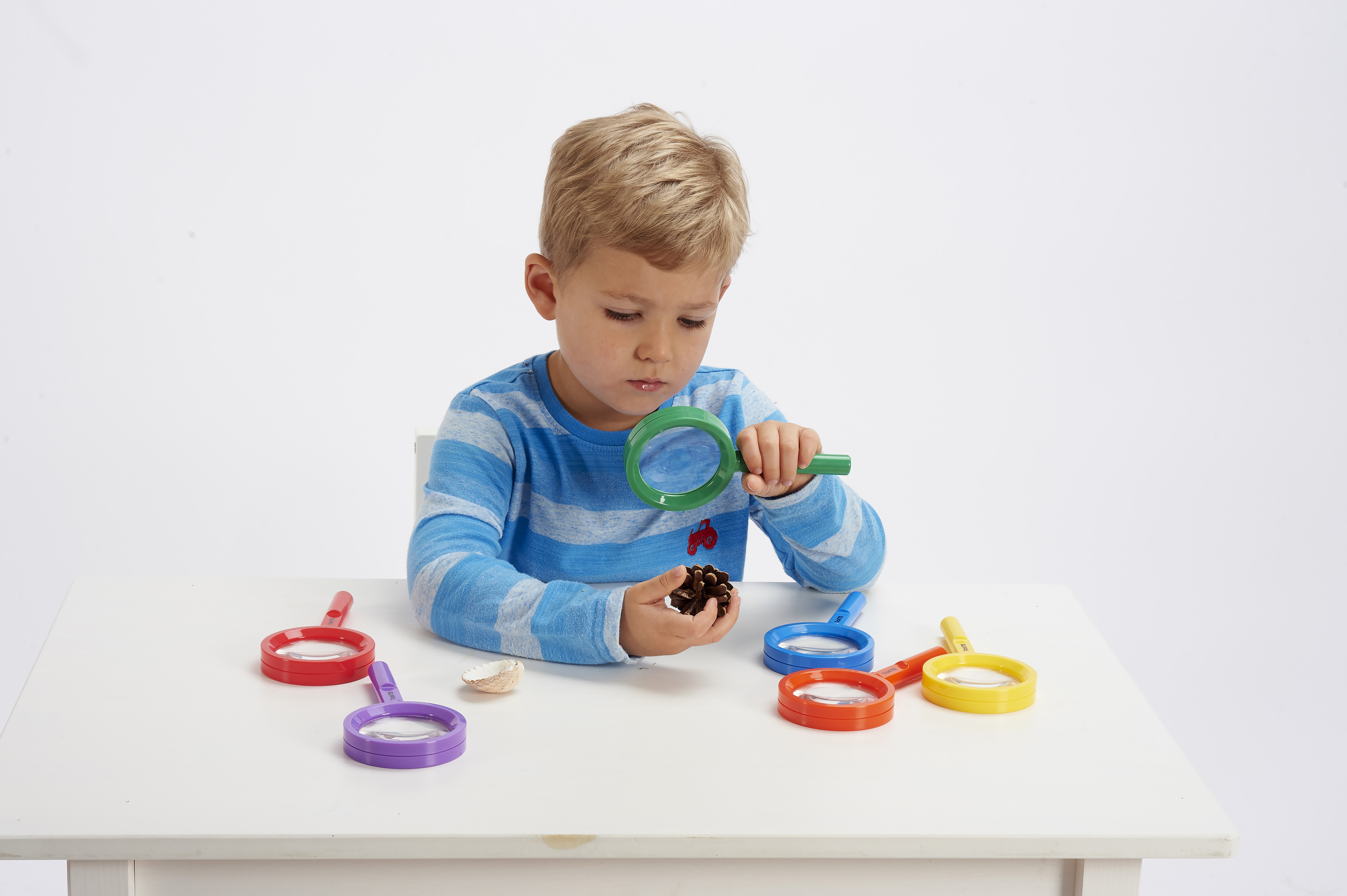 Kind untersucht Gegenstand mit Rainbow Kinder Lupe Kind untersucht Gegenstand mit Rainbow Kinder Lupe