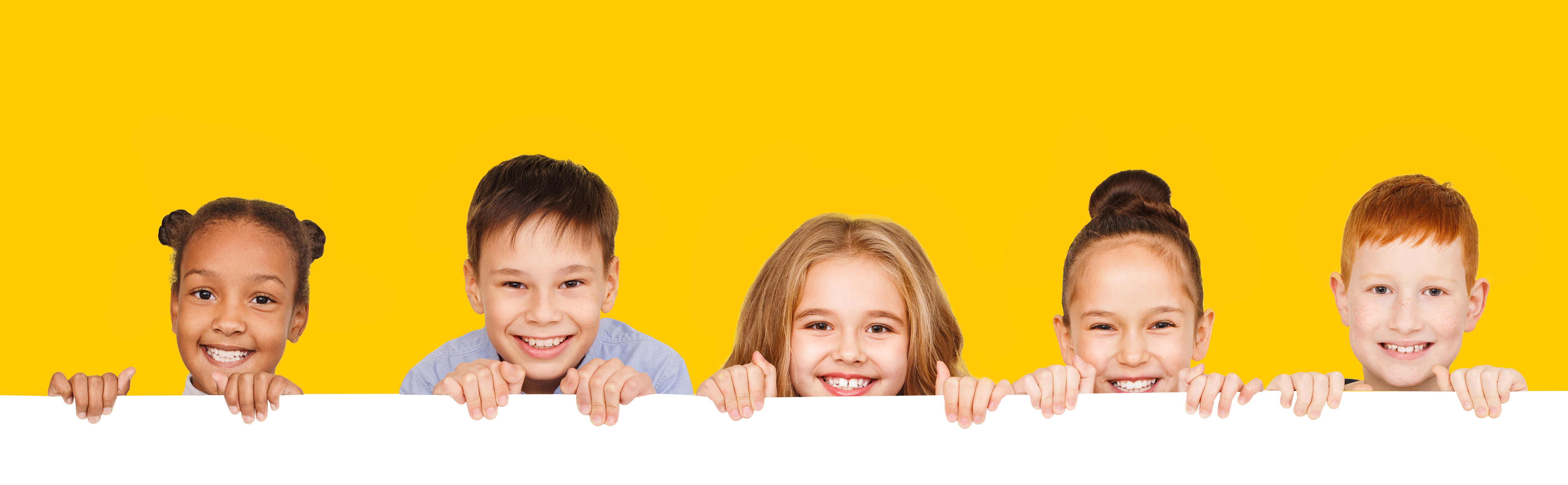 Fünf Kinder schauen lachend über eine Mauer Kontakt-Fünf Kinder schauen lachend über eine Mauer