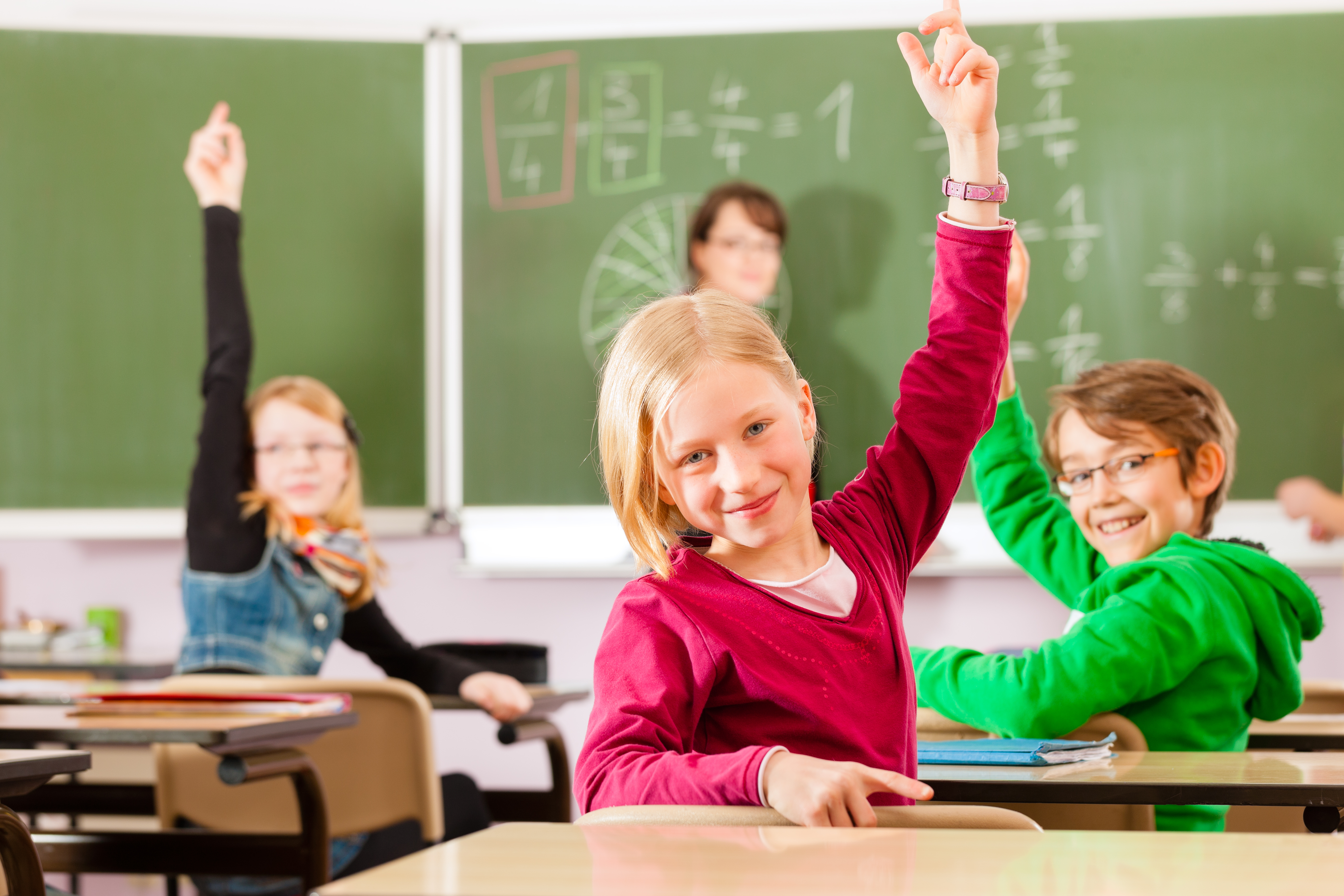 SchülerInnen zeigen im Klassenzimmer auf